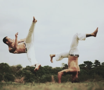 Mestre Cristopher e Mestre Simpson jogando capoeira